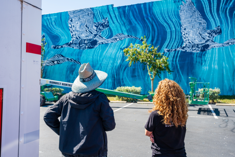 Jenne Priebus and artist HOXXOH (Douglas Hoekzema) n front of his mural for SHINE 2023. Photo by Mark Rapien